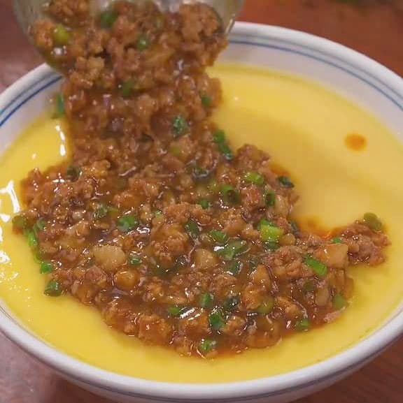 pour the cooked minced pork mixture over the steamed eggs