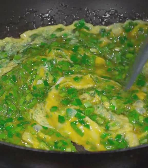 Once the fat is hot pour in the egg and chive mixture