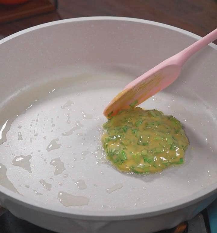ladle a portion of the chive batter into the pan